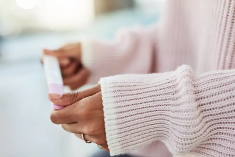 Close up shot of woman holding pregnancy test