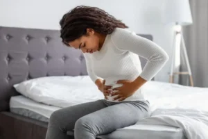 Woman holding stomach in pain representing endometriosis and fertility challenges
