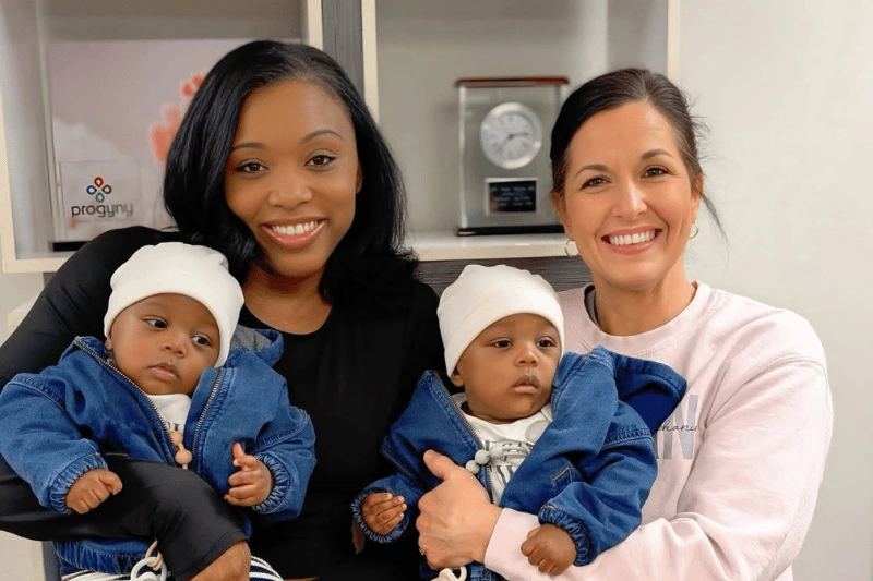 PREG fertility patient with their babies and a nurse at a fertility clinic