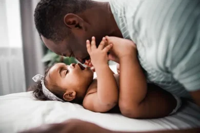 A close up shot of father playing with his young baby girl