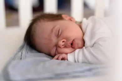 Sweet newborn baby is asleep on mother’s chest